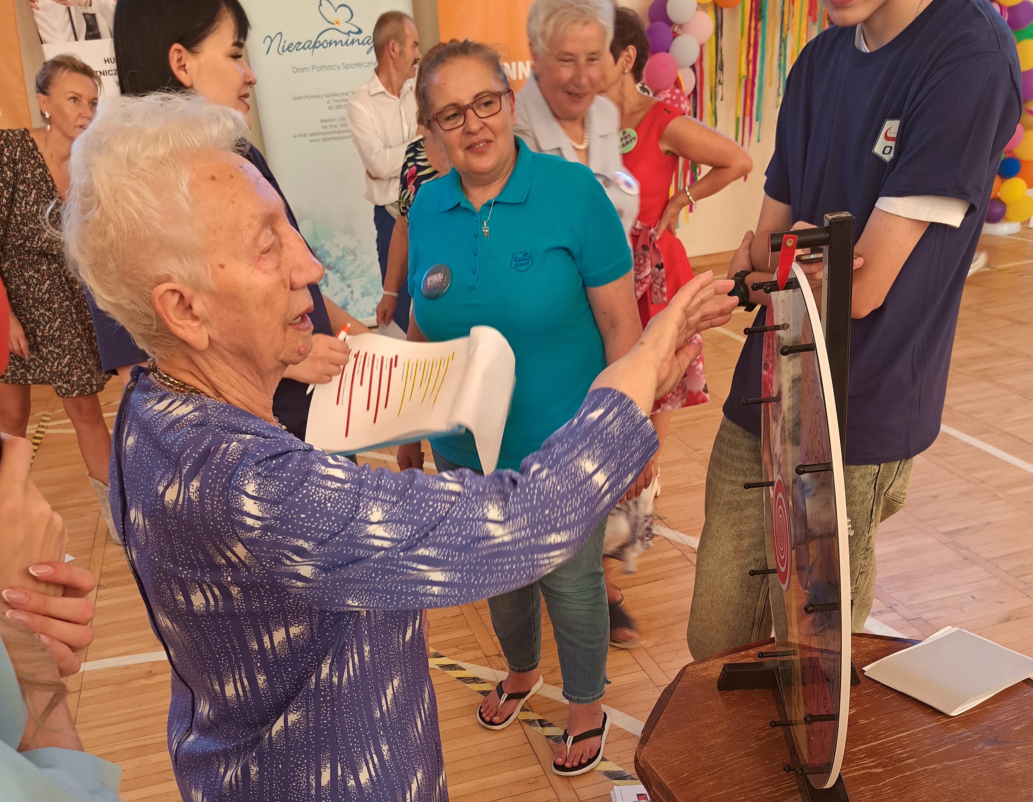 Seniorka podczas kręcenia mini kołem fortuny