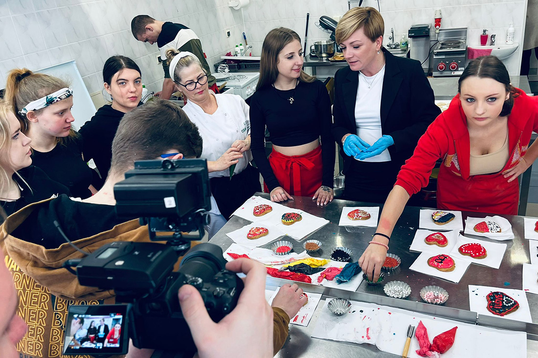 Na zdjęciu widać grupę młodzieży wraz z Wojewódzką Komendant podczas warsztatów gastronomicznych i ozdabiania lukrem pierniczków.