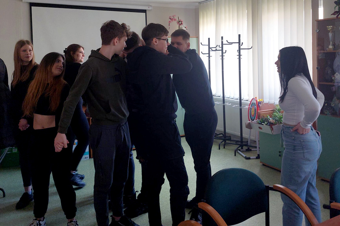 Zdjęcie przedstawia roześmianą grupę młodzieży podczas warsztatów.